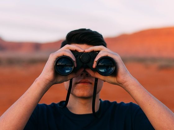 A man looking through binoculars